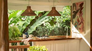 A kitchen with a wooden countertop, two hanging pendant lights, a coffee maker, and a sink. - Mid Tide Bungalow - Walking distance to the Surf and Restaurants (Santa Teresa Beach)