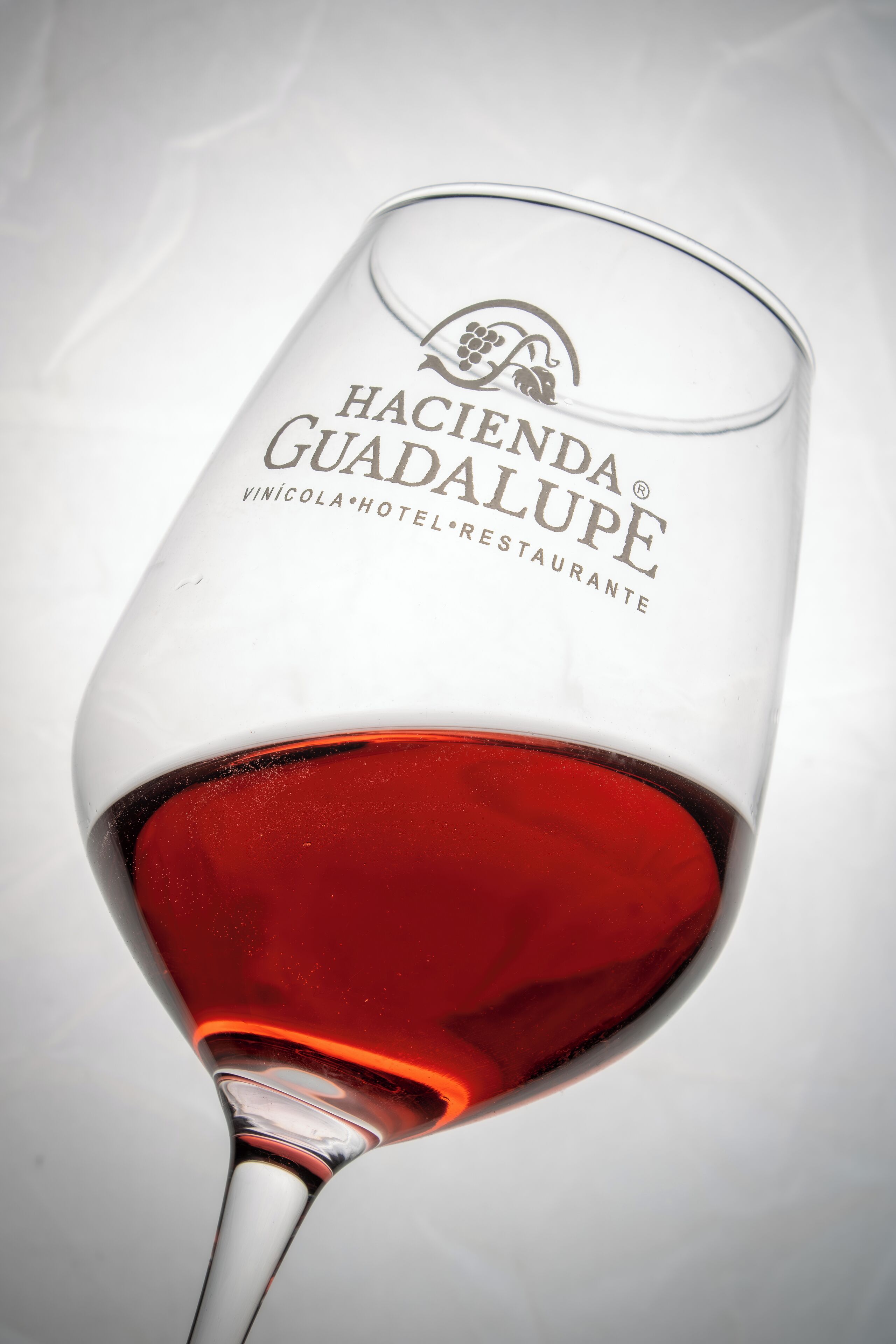 A wine glass with the text "Hacienda Guadalupe Vinícola Hotel Restaurante" engraved on it.