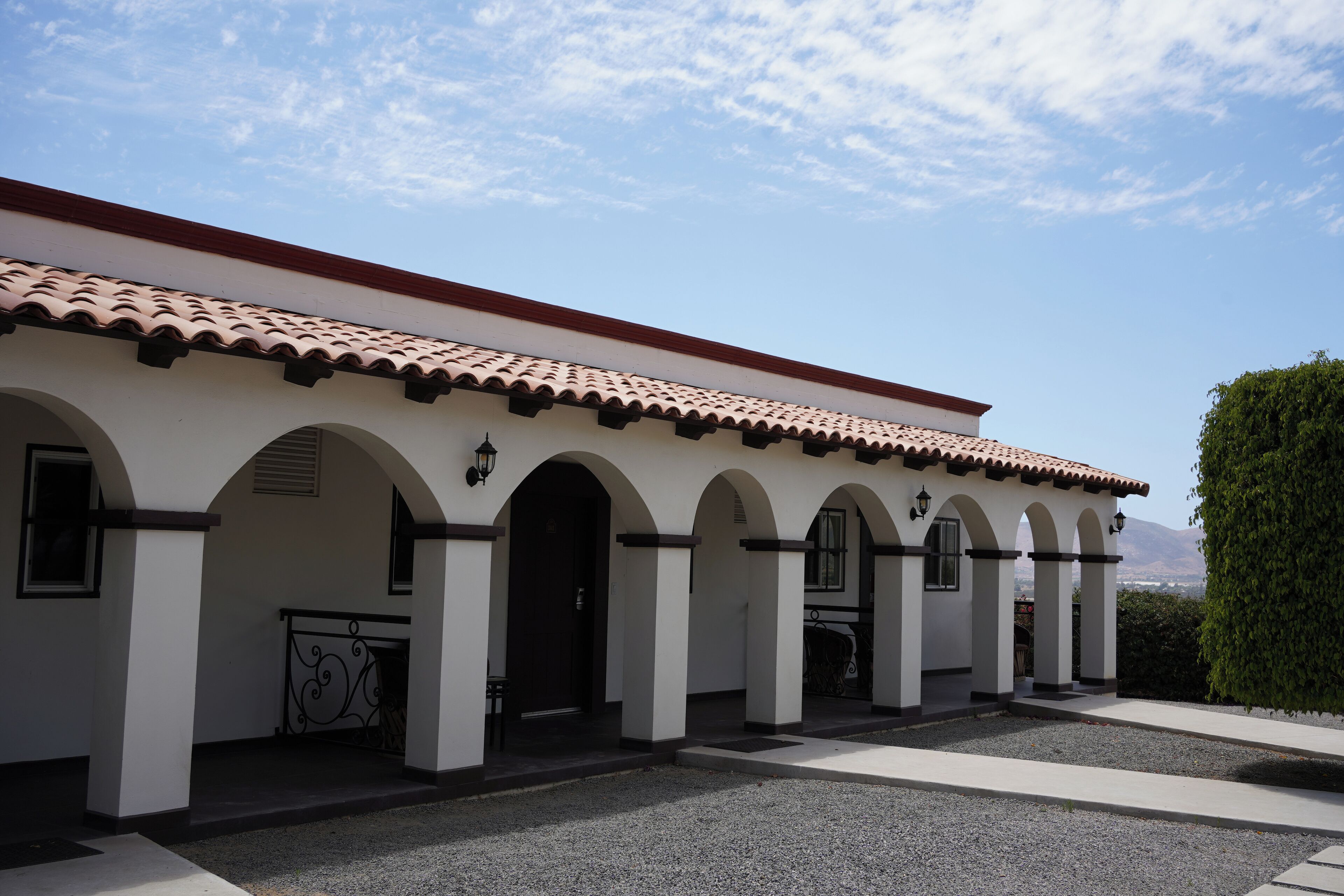 A building with a tiled roof, white walls, and multiple arches.