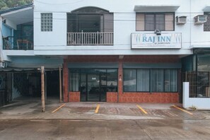A two-story building with a sign for 'Raj Inn Jordan'.