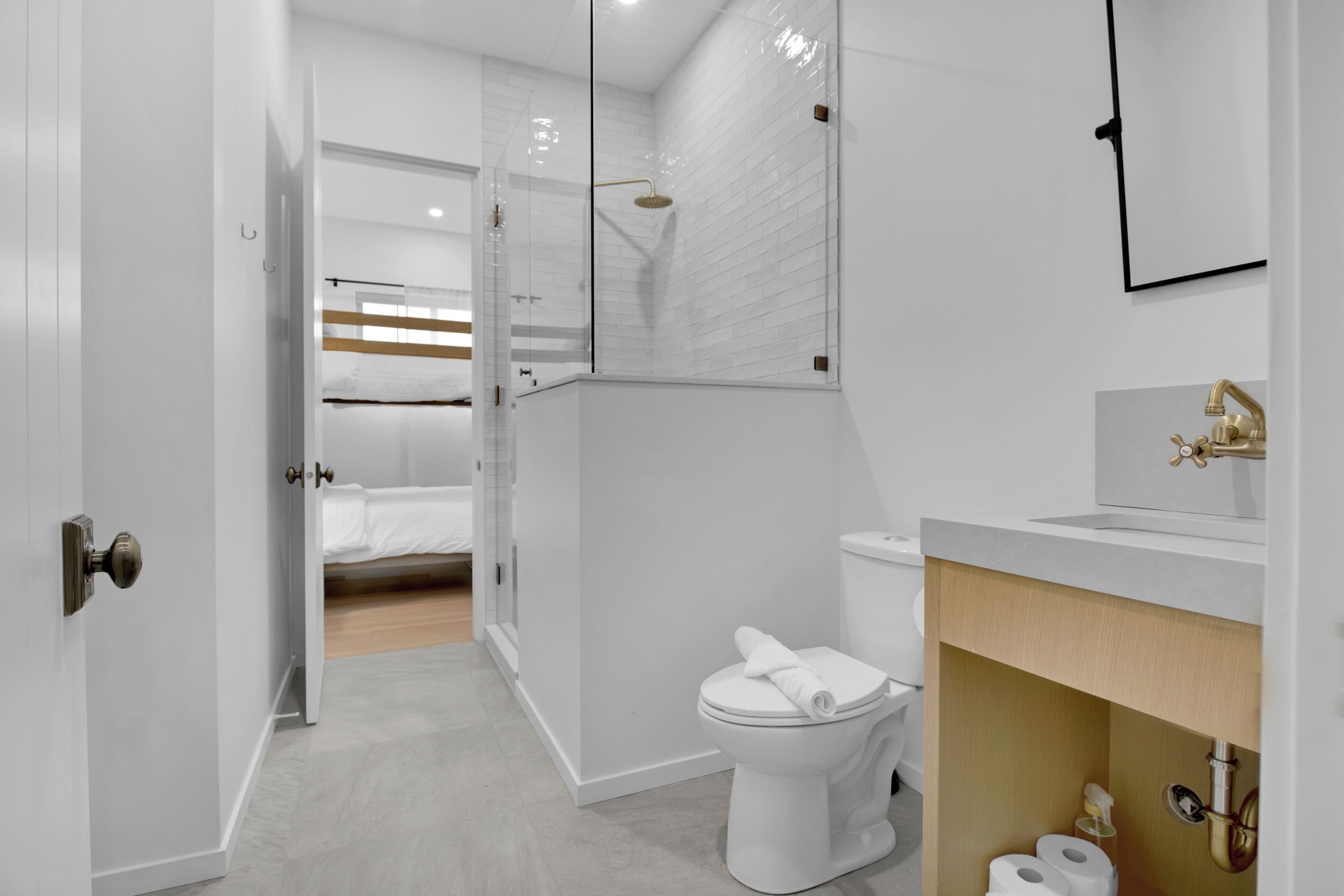 A modern bathroom with a toilet, sink, and shower.