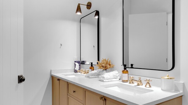 A modern bathroom with two sinks, a large mirror, and a towel rack. - Modern home with 2 master bedrooms, private hot tub, garage and mountain views (Silver Star Mountain)