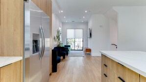 A modern kitchen with wooden cabinets, a stainless steel refrigerator, and a built-in water dispenser. - Modern Luxe Retreat Three-Bedroom #4 (Los Angeles)