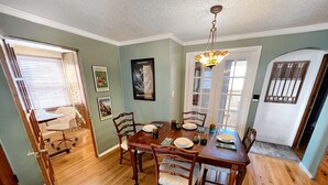 Comedor con mesa de madera dispuesta para cuatro personas, rodeado de sillas.