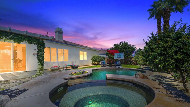 A swimming pool with a hot tub, surrounded by a patio area with outdoor furniture. - Charming 4-bedroom house with private pool and spa in brilliant Indio (Indio)