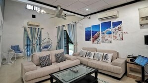A modern living room with a sofa set, a coffee table, a ceiling fan, and a TV. - Yussy Homestay at Afamosa Villa (Alor Gajah)