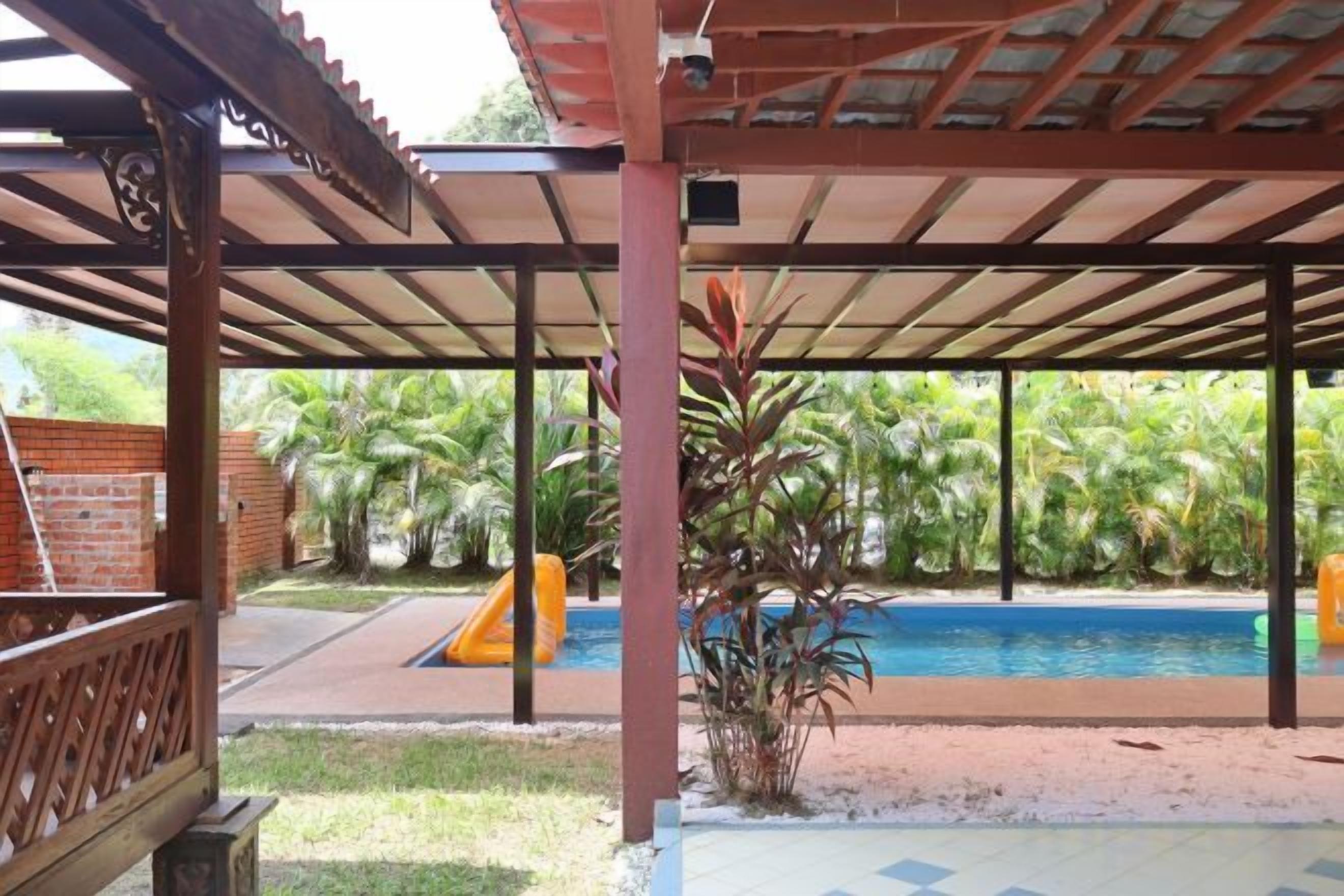 Un espacio al aire libre cubierto con piscina, tobogán y pared de ladrillo.