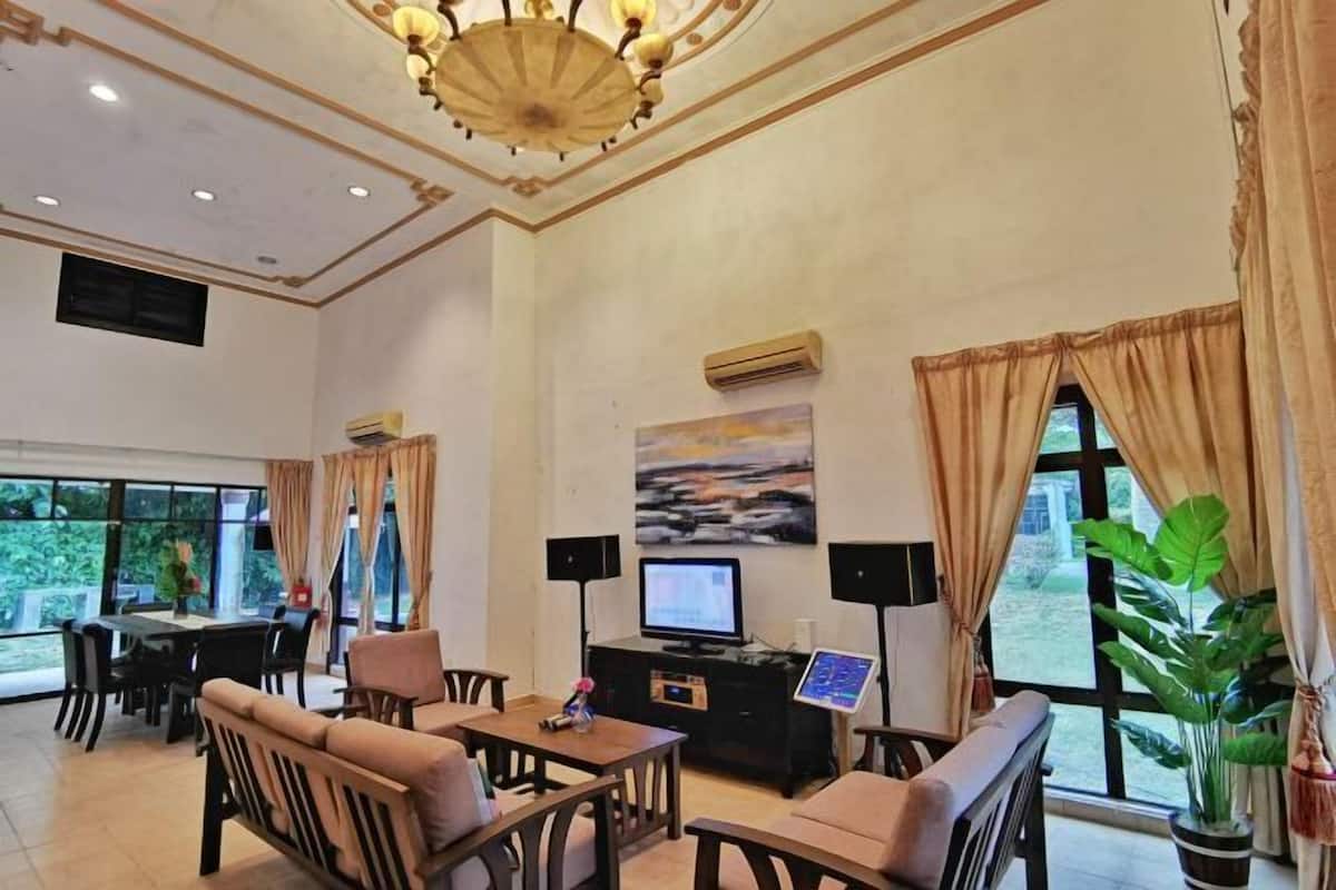 A spacious room with a dining area, a television, and a large window with curtains.