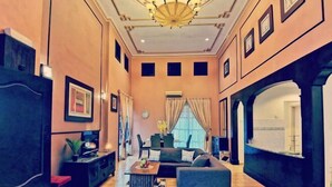 A spacious living area with a sofa, coffee table, and a dining table with chairs. - Yussy Homestay at Afamosa Villa (Alor Gajah)