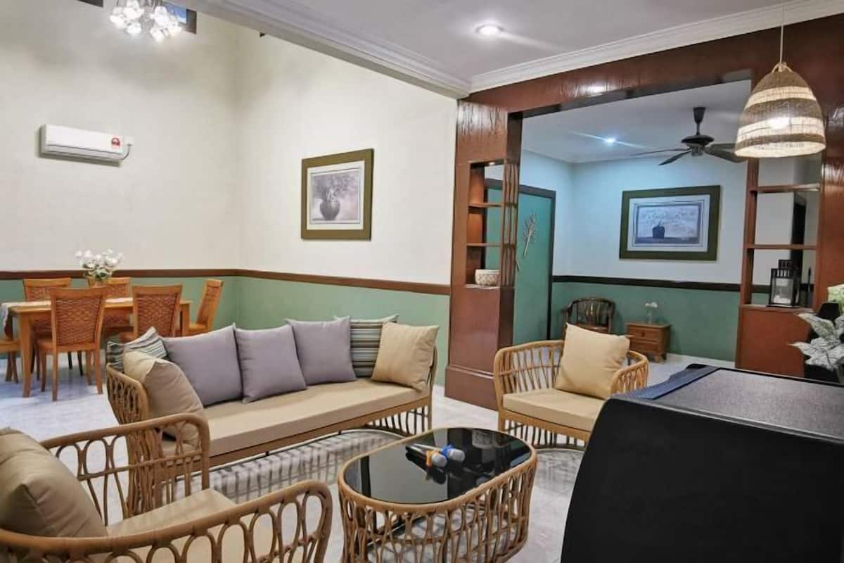 A living room with a sofa, chairs, a dining table, and a TV.