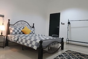 A neatly made bed with a checkered bedspread and a single yellow pillow. - Sky312 Muslim Homestay (Langkawi)