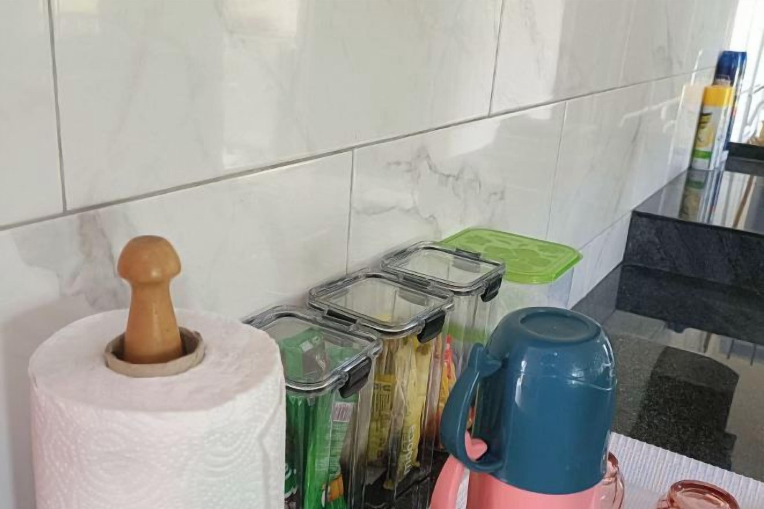 Un comptoir de cuisine avec un porte-essuie-tout, une machine à café et des récipients.