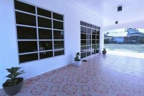 A covered outdoor area with large windows, potted plants, and a tiled floor. - Sky312 Muslim Homestay (Langkawi)