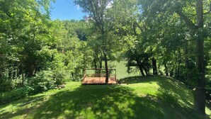 A wooden deck with a metal railing overlooking a grassy area with trees. - River Relaxation - Calm Riverfront Home in Winchester Kentucky (Winchester)
