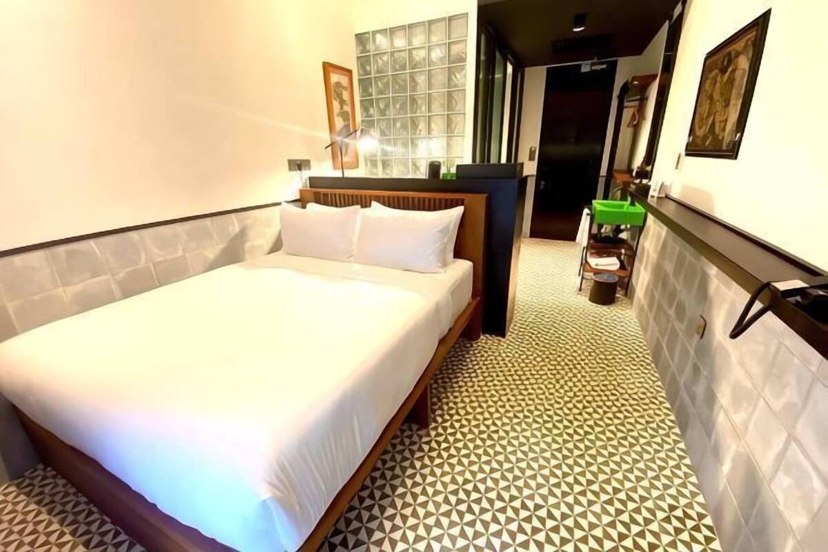 Een hotelkamer met een bed, een klein tafeltje en een stoel.