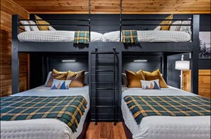A bunk bed room with two beds, each with a plaid blanket and pillows. A ladder is between the beds. - Freshly Renovated! 3 Pools, Pickleball, Hot Tub, Game Rm! (Gatlinburg)