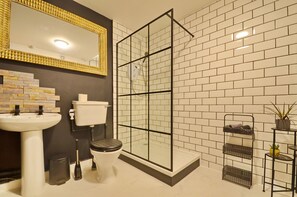 Een douche, handdoeken, zeep, toiletpapier