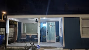 A house with a covered porch, a front door, and a small garden area. - 3-bedroom 2 full bath bungalow in the heart of the city minutes from DT Raleigh. (Raleigh)