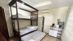 A bunk bed room with a small desk and a coffee maker.
