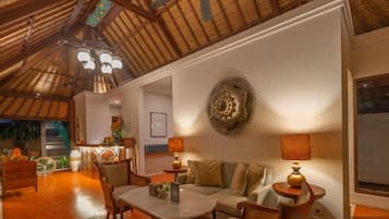 A cozy living area with a high ceiling, a dining table, and a sofa.