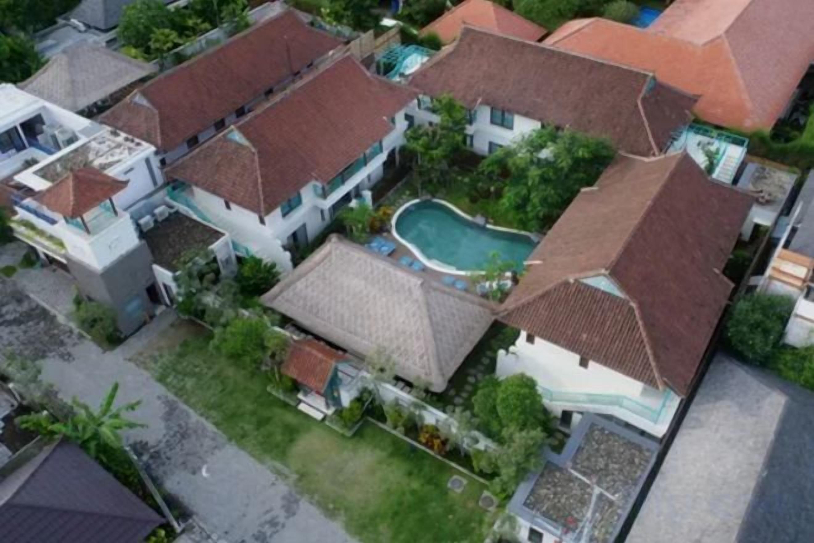 A residential area with multiple houses, a swimming pool, and a well-maintained garden.