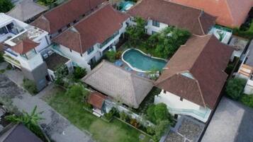 A residential area with multiple houses, a swimming pool, and a well-maintained garden.