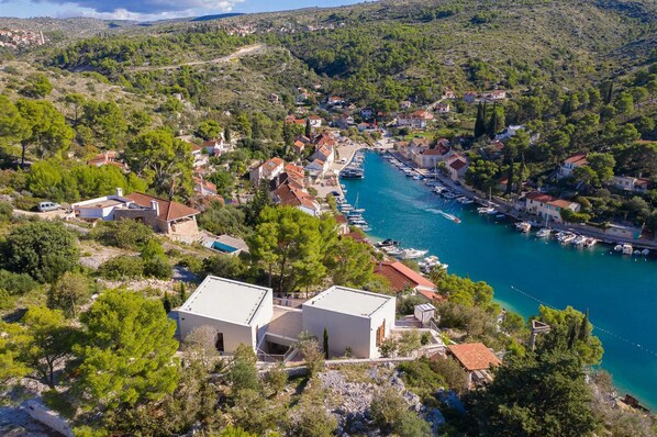 Un pueblo costero con casas, un puerto deportivo y un mar azul cristalino.