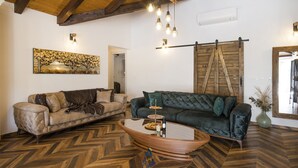 Un salón con dos sofás, una mesa de centro de madera y un suelo con diseño de espiga.