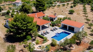 Una villa moderna con piscina, varias habitaciones y jardín.
