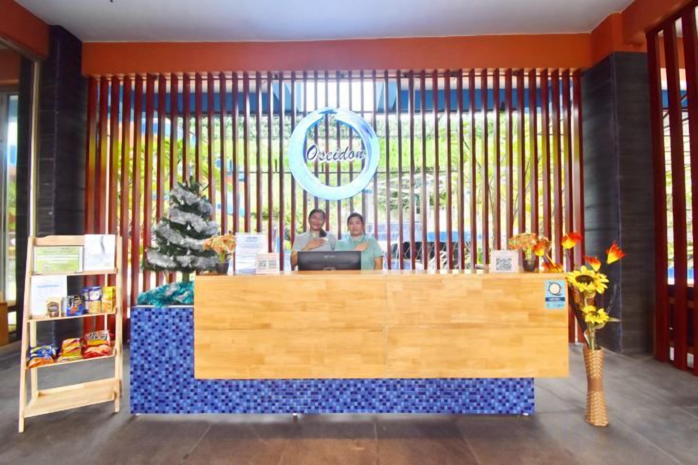 A reception desk with a blue tiled base, a wooden counter, and a Christmas tree decoration.