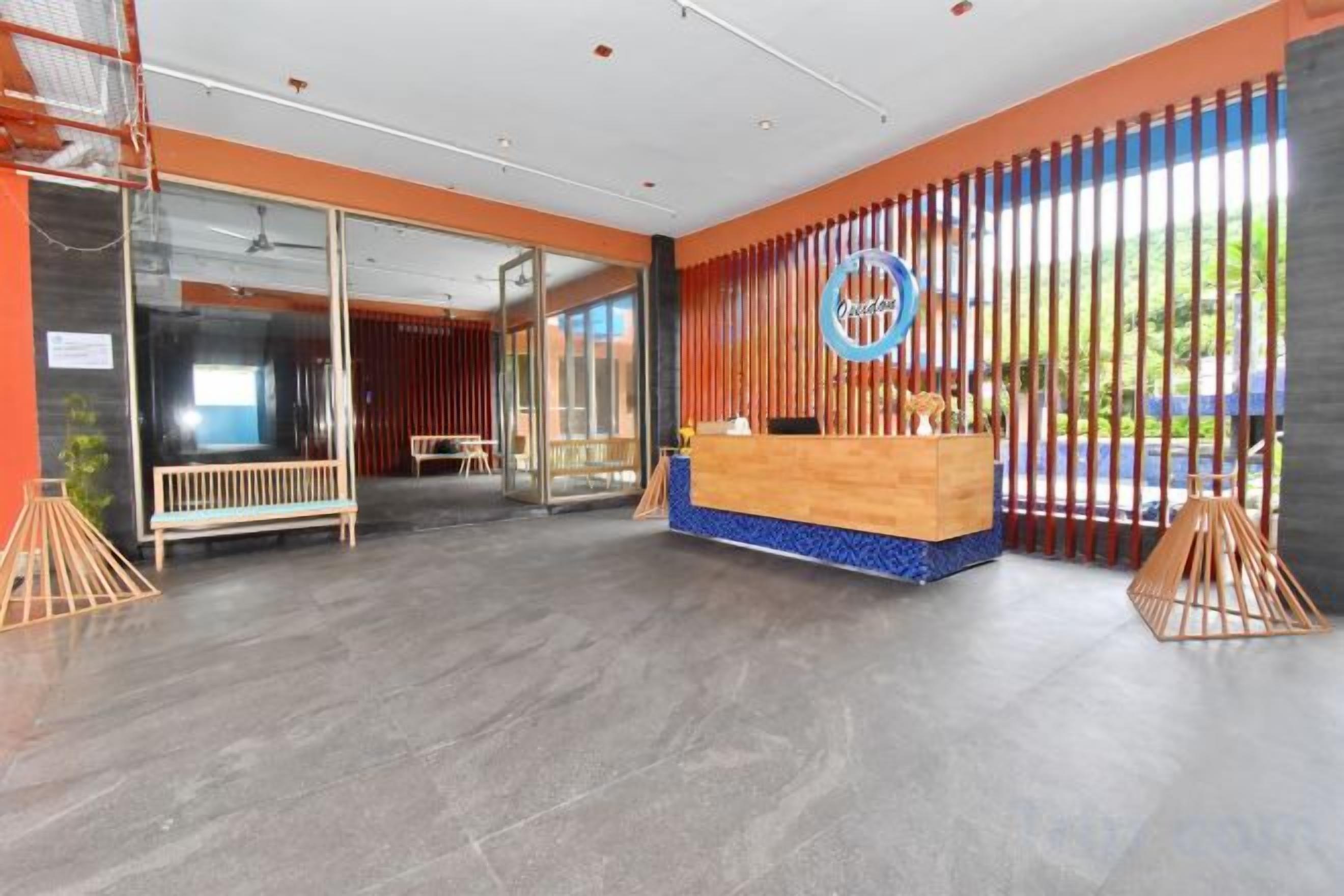 A reception area with a wooden reception desk, a glass partition, and a view of the outdoors.