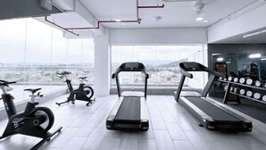 A gym with treadmills, stationary bikes, and a weight rack. - Paradise Perch Tanjung Aru Inifnity Pool 2BR (Kota Kinabalu)