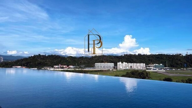A large body of water with a clear sky, a mountain range in the background, and a building with a prominent 'P' logo. - Paradise Perch Tanjung Aru Inifnity Pool 2BR (Kota Kinabalu)