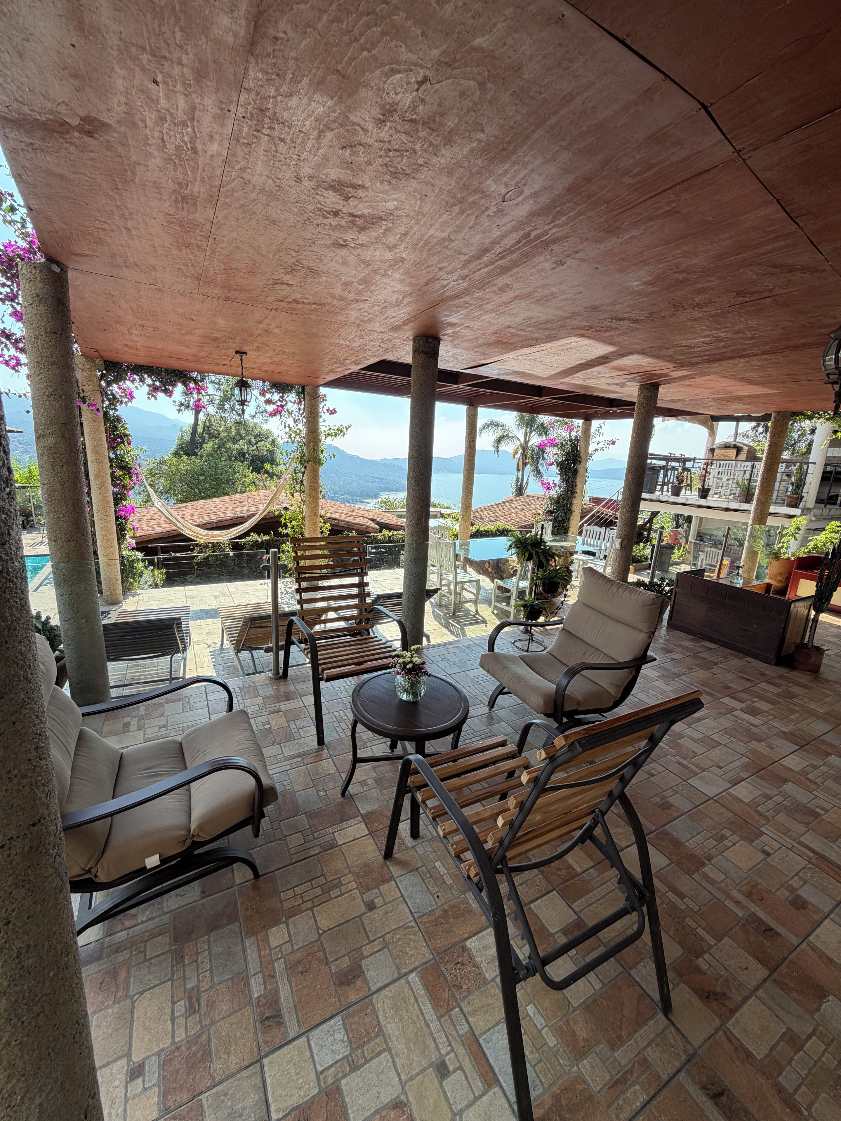 An outdoor patio with seating, a pool, and a view of the ocean.