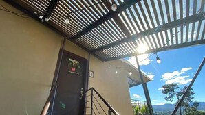 En trappe fører op til en balkon med udsigt over et bjerrelandskab.