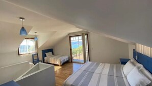 Een slaapkamer met een bed, een stoel en een raam met uitzicht.