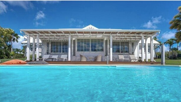 A large, white building with a covered patio area and a swimming pool in front. - Villa TERRAVIVA- Saint François  8 pers.- 4 ch- 3 sbb, piscine, WiFi, AC (Saint-François)