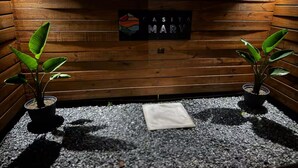 A wooden wall with a sign reading "CASITA MARY" and two potted plants on a gravel floor.