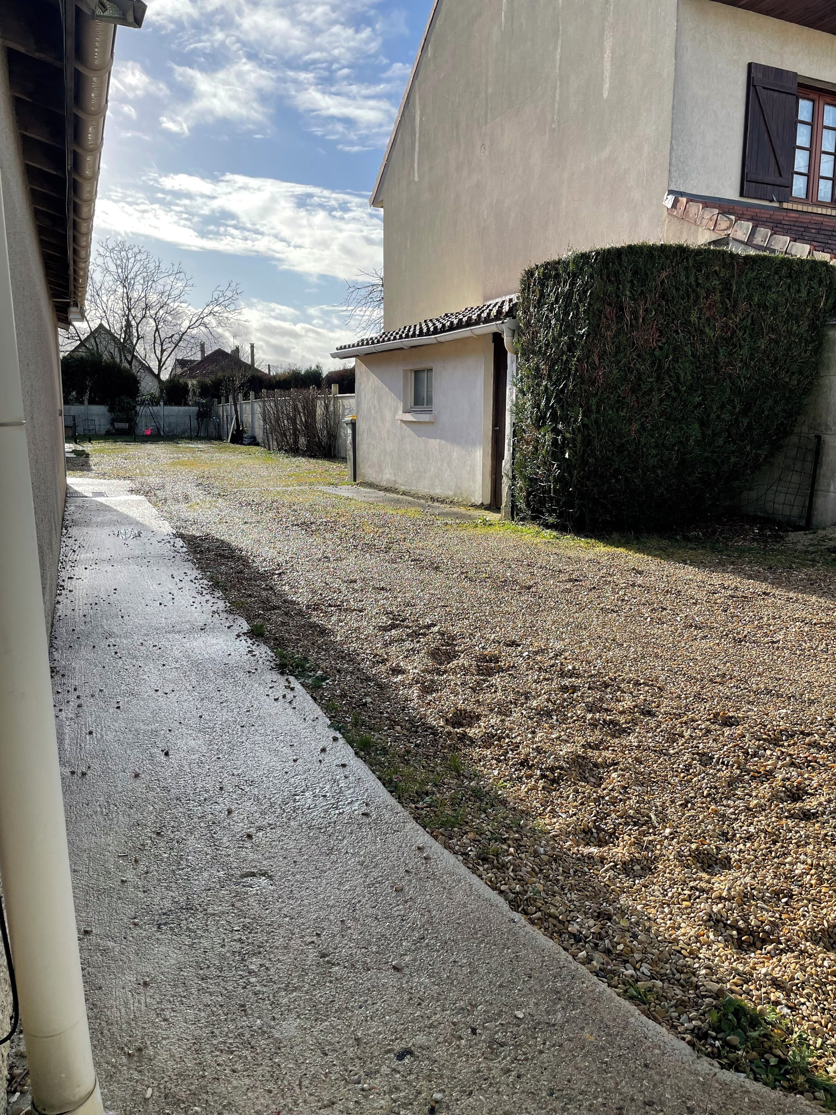 Ein Wohngebiet mit einer gepflasterten Auffahrt, die zu einem Haus mit kleiner Garage führt.