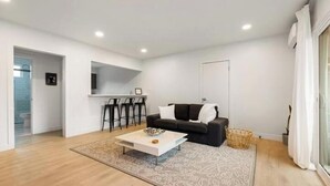 Un salon moderne avec un canapé blanc, une table basse et un tapis à motifs.