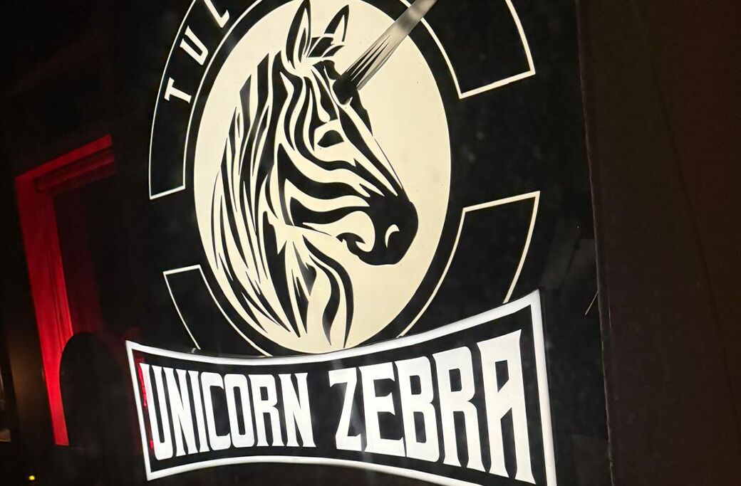 Et logo med en stiliseret enhjørning og teksten 'UNICORN ZEBRA'.
