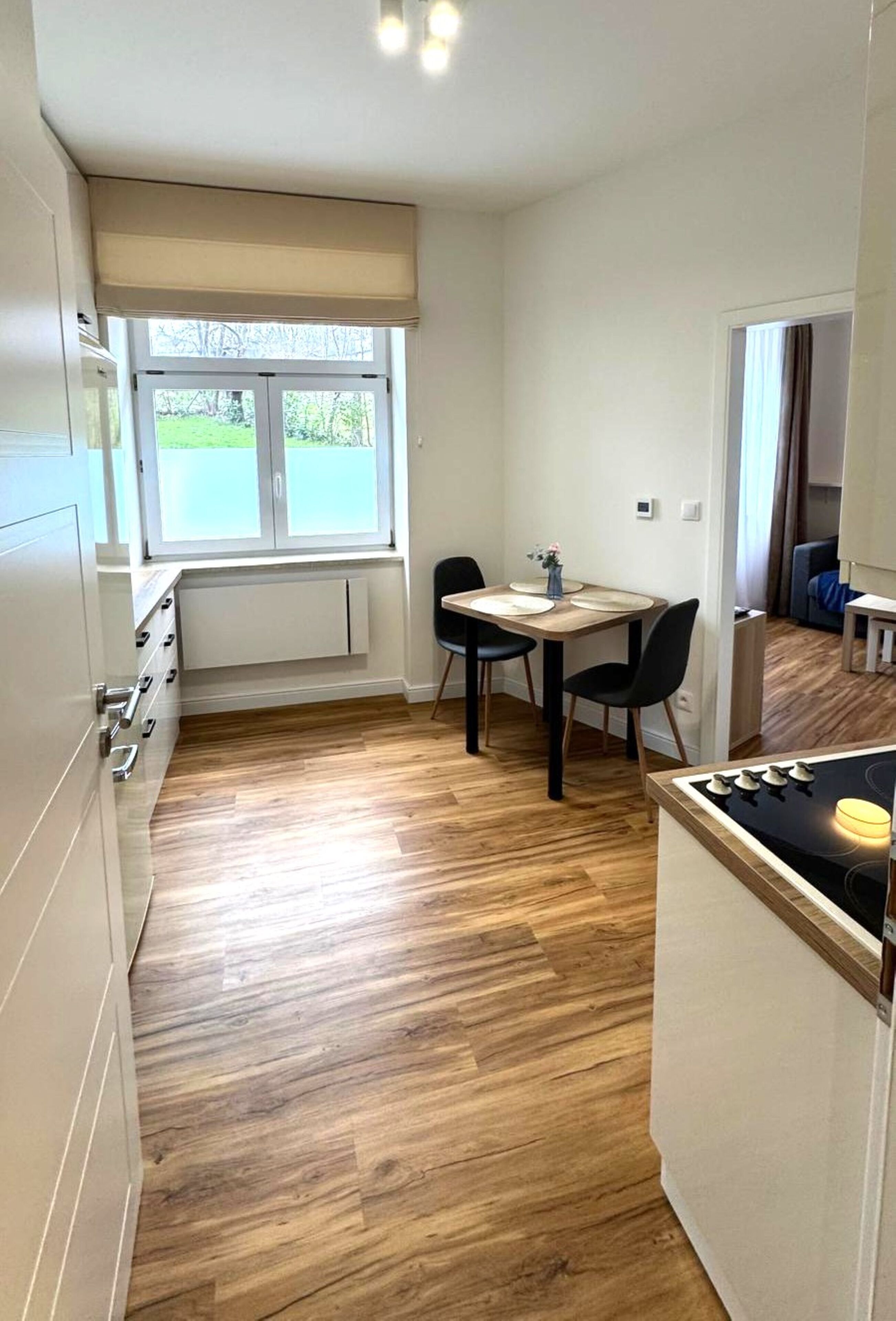 Une cuisine compacte avec un coin repas, un plancher en bois et une fenêtre offrant une belle vue.