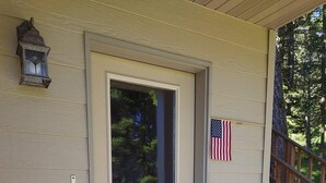 Eine Tür mit Fenster, eine amerikanische Flagge, eine Fußmatte und eine Schwein-Statue.
