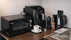 A kitchen with a microwave, coffee maker, and coffee pot. - Nexus Rentals Tallinn (Tallinn)