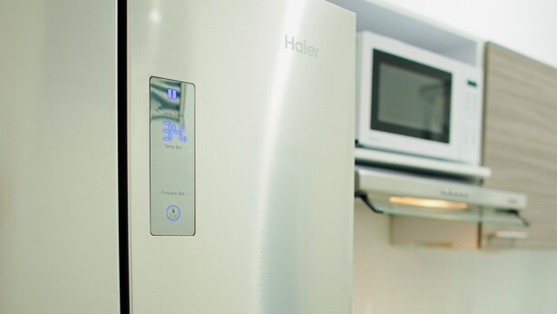 A modern kitchen with a stainless steel refrigerator, a microwave, and a gas stove.