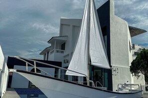 Un velero amarrado cerca de un edificio moderno con una vela grande.
