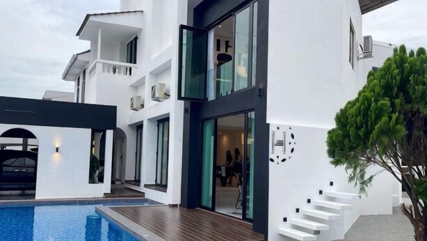Edifici modern amb piscina, escala i una banca de fusta.