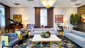 A hotel lobby with a grand piano, sofas, a coffee table, a chandelier, and artwork on the walls. - Alhambra Hotel (Alhambra)