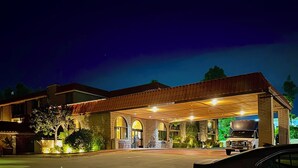 A two-story building with a covered entrance and a truck parked outside. - Alhambra Hotel (Alhambra)