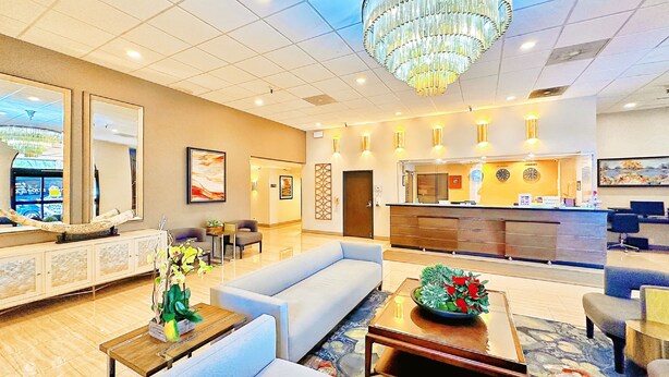 A hotel lobby with a reception desk, seating area, and a chandelier. - Alhambra Hotel (Alhambra)